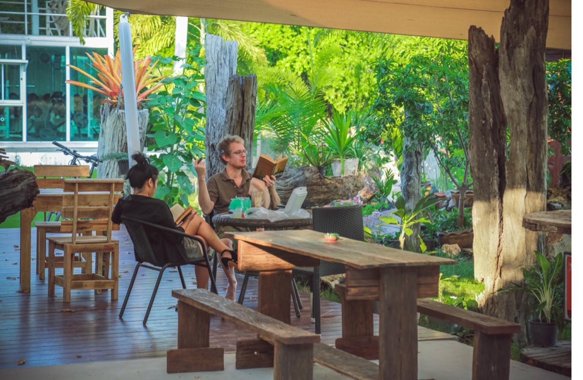 Guests reading and relaxing in the garden at Tree Roots Retreat, Rayong