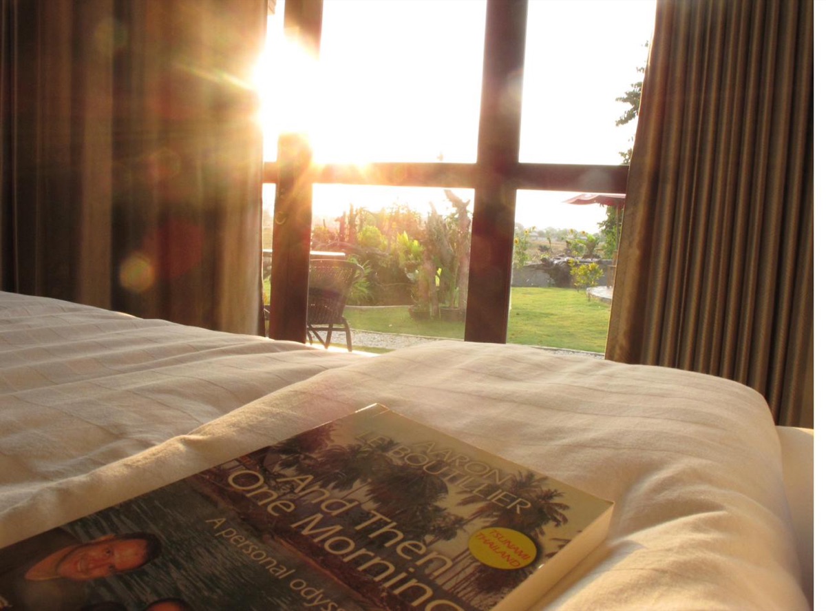 Inside a room at Tree Roots Retreat, morning light over the bed and garden, Rayong