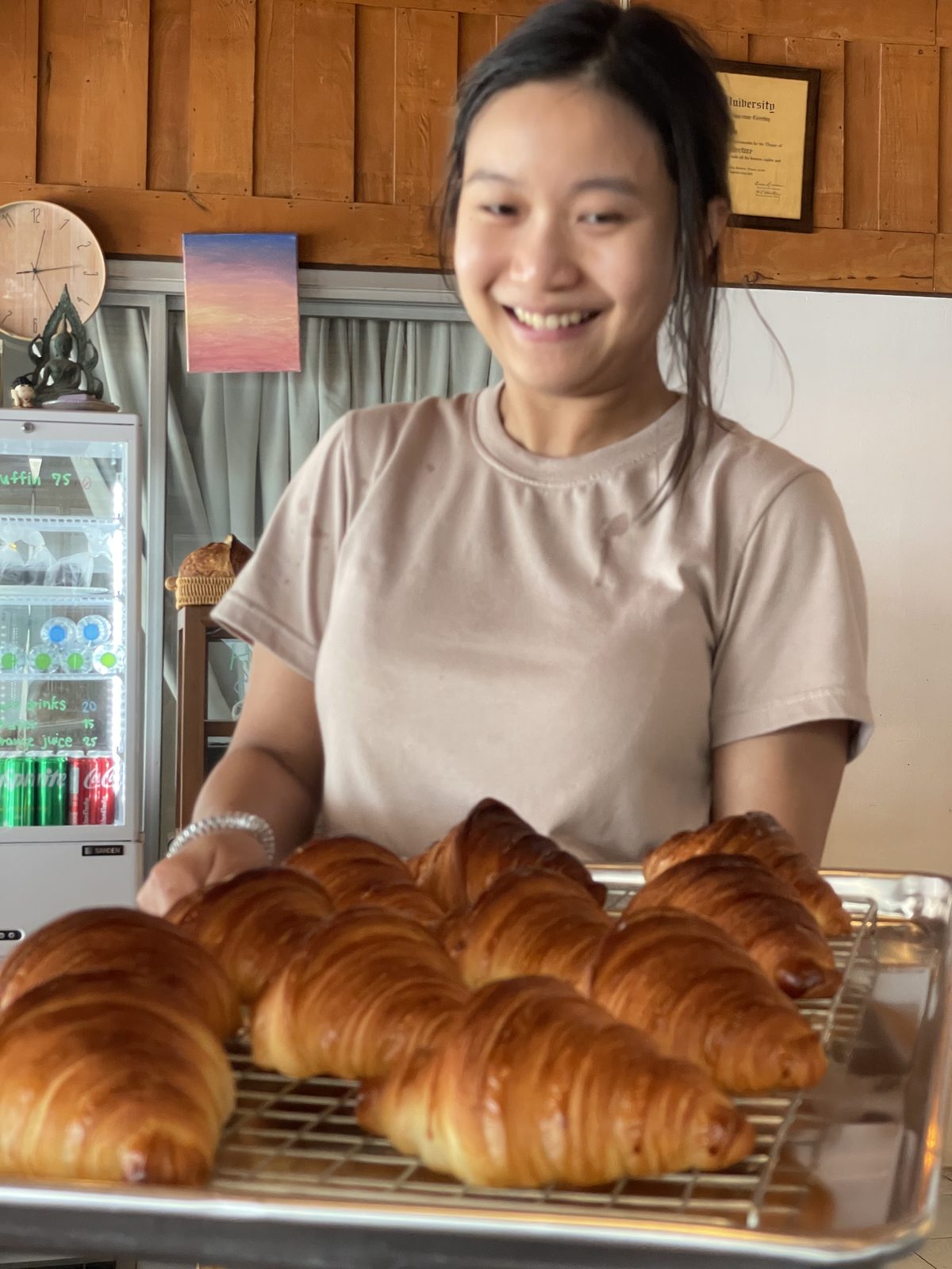 Psy holding a tray of fresh-baked croissants at Stay Cafe on Mae Ram Phueng beach, Rayong &mdash; the eighth attempt, golden and laminated.